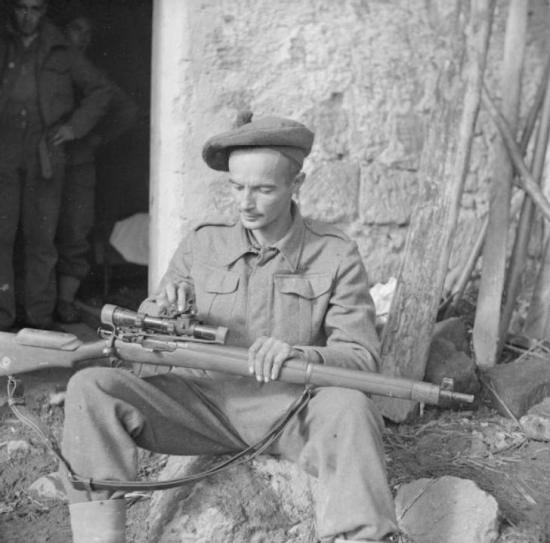Lance Corporal A P Proctor, a sniper with 56th Division, cleaning his rifle, 24 November 1943.